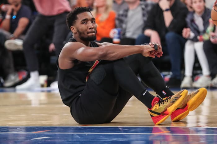 Cleveland Cavaliers guard Donovan Mitchell sits on the court after a foul.